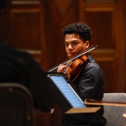 罗彻斯特大学的一名学生在音乐会上演奏小提琴.