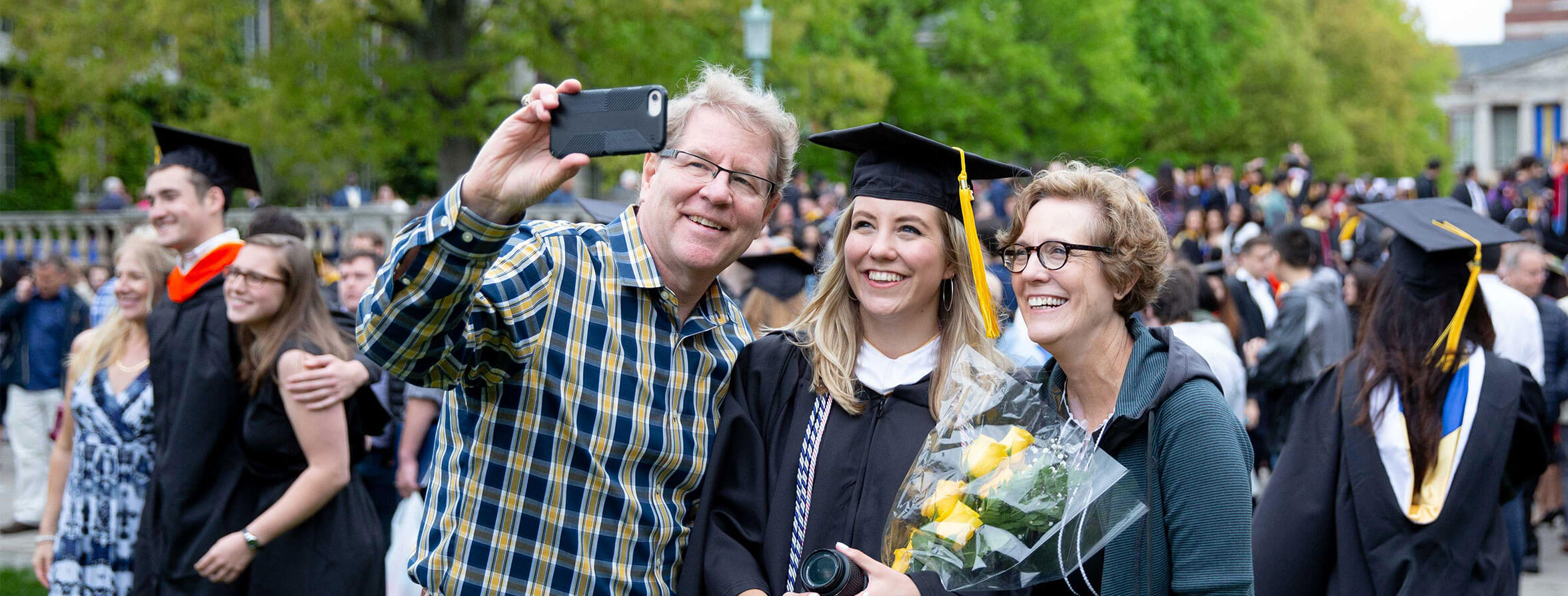 Student poses for photo with their relatives at University of Rochester