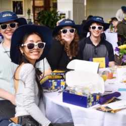 Three University of Rochester sophomores posed together while wearing University of Rochester hats. 
