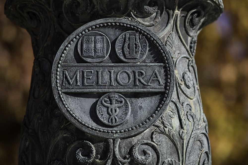 The meliora shield on a lamp post in the Eastman Quad.