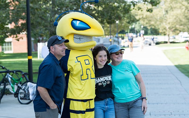 A student and their parents pose with Rocky on Wilson Quad during move-in day