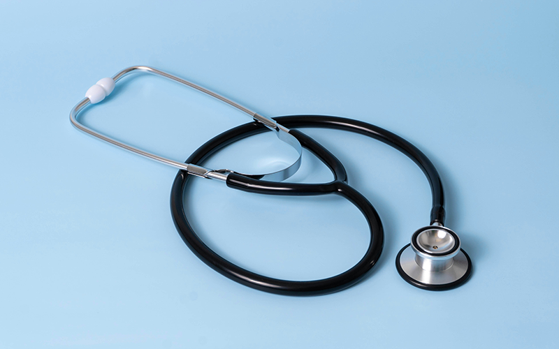 A stethoscope sits on a light blue background