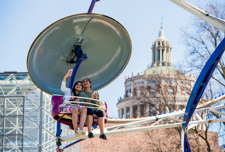 Photo of two students snapping a selfie on a carnival ride during a previous Springfest Weekend