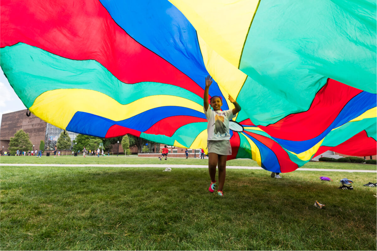 Young child runs under parachute at University of Rochester
