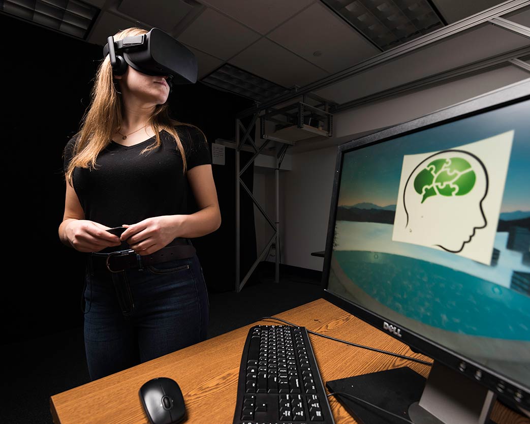 Student stands, wearing virtual reality glasses