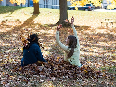Students playing in fall leaves