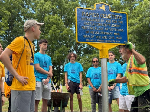 Students watch as a working talks about a sign.