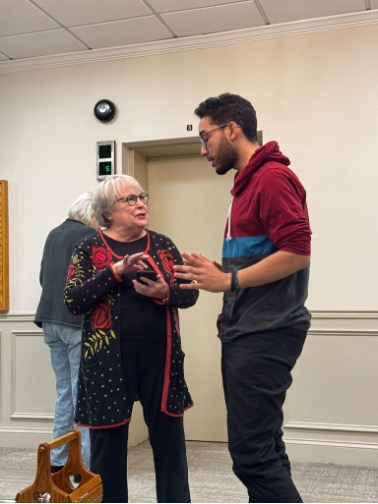 A man speaking to an older woman.