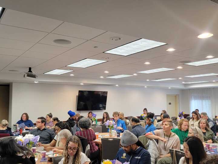 A full room of attendees seated at tables.