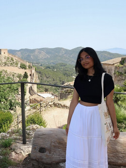 Anushka standing in front of a mountain village.