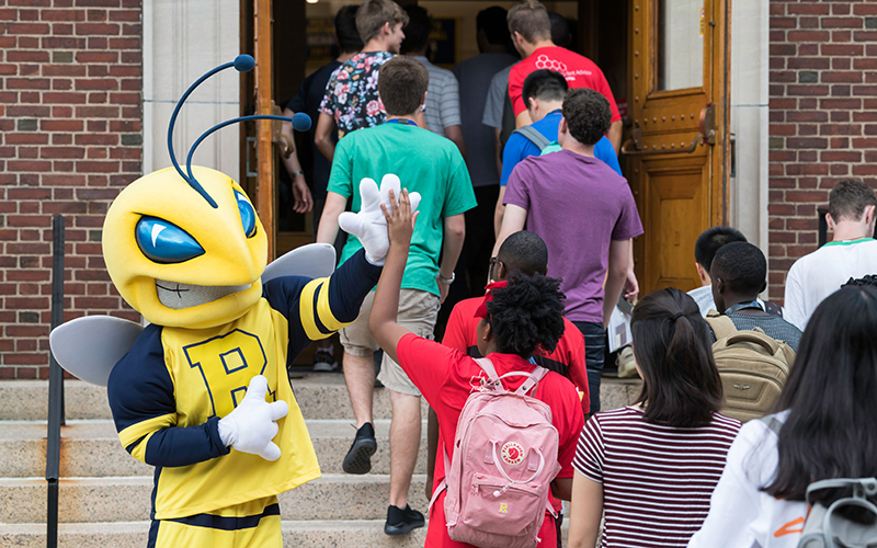 Photo of Rocky high-fiving a student as they enter the Palestra during a previous Welcome Week