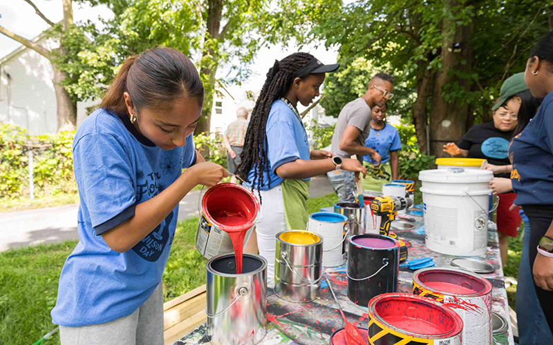 Students pouring paint and organizing paint cans