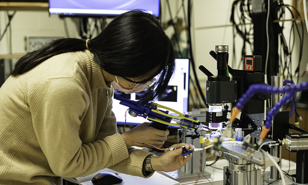 A student working with tools in a lab.