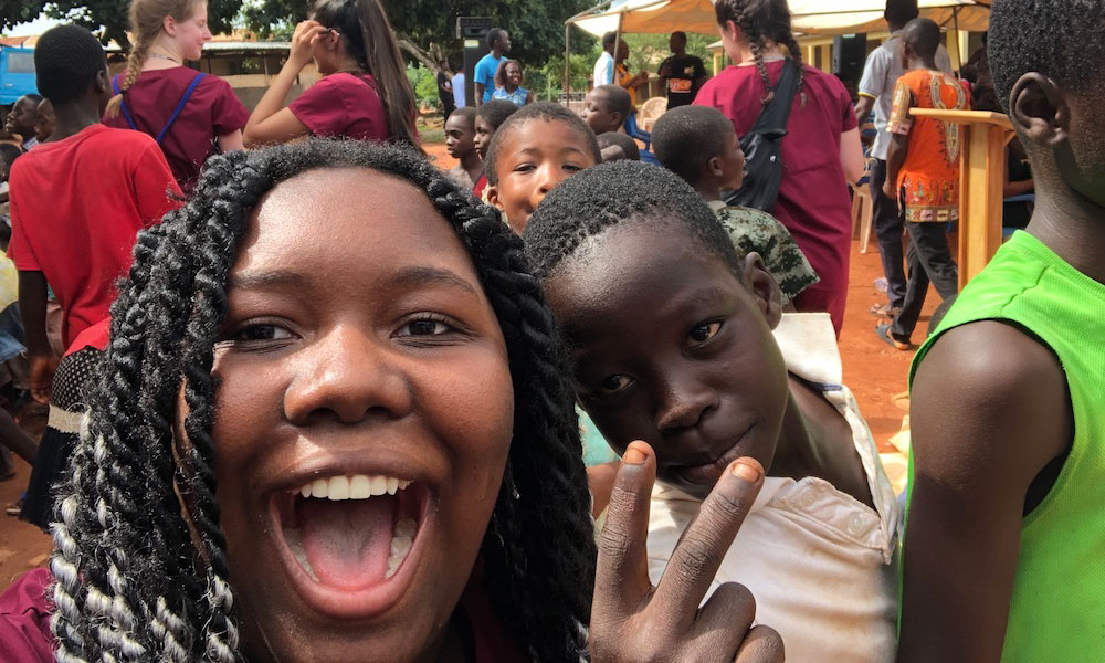 A student in Ghana takes a selfie with her local friends.