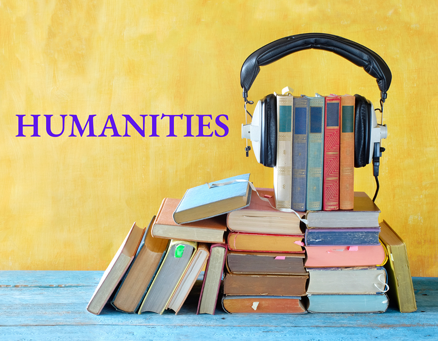 A pyramid of books with headphones on the top of them.