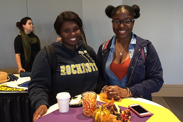 Two students smiling in front of plates of appetizers