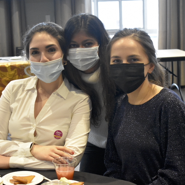 Three masked students sitting at a table together