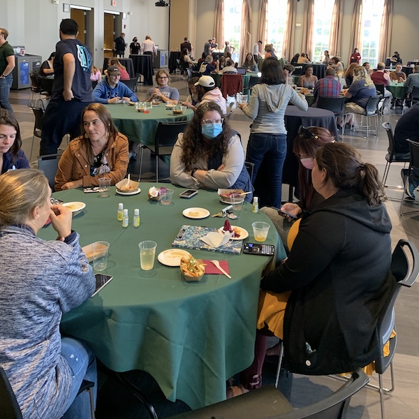 Wide shot of many tables of people eating and drinking