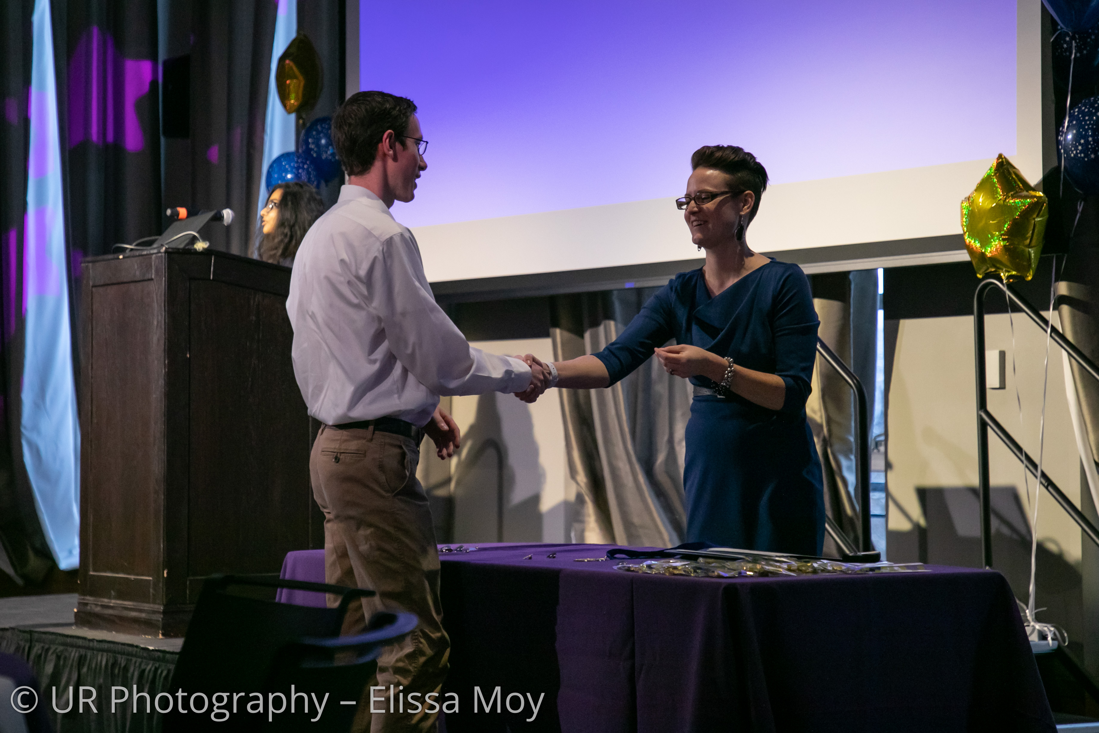 Stacey Fisher shaking hands with an award recipient