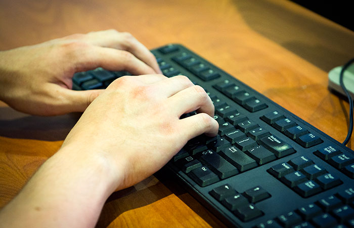 Hands on a computer keyboard.