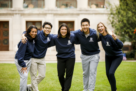 Five Rochester students in blue and grey Rochester-branded apparel 