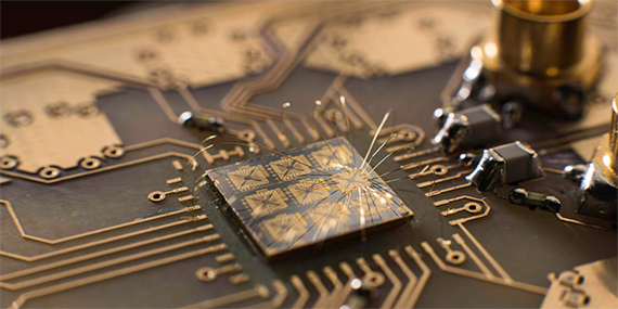 A quantum processor semiconductor chip connected to a circuit board.