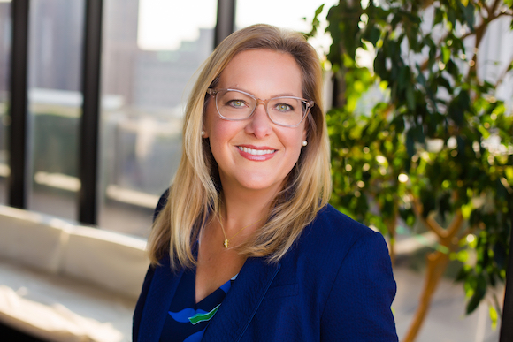 Headshot of Courtney Spitz in blue top with glasses