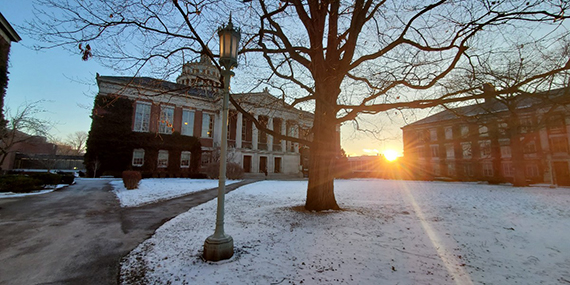 The sun rises on a snow-covered Eastman Quadrangle.