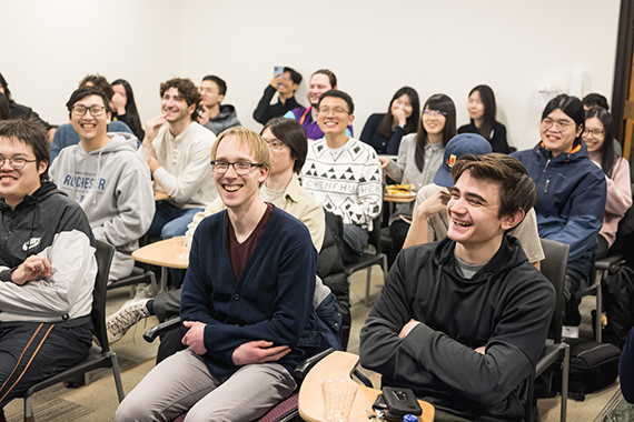 A classroom full of optics students sitting at their desks and laughing.