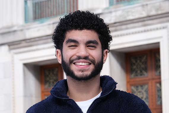 A headshot of Omar Zakaria Khalil standing in front of the Rush Rhees Library.