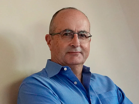 Danny Sabbah wears glasses and a blue shirt.