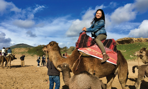Student riding camel abroad