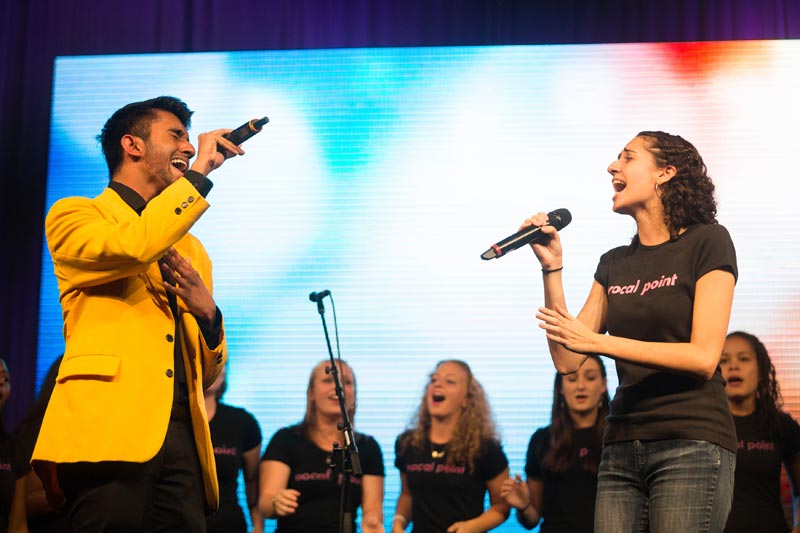 performers from two a cappella groups performing a duet on stage