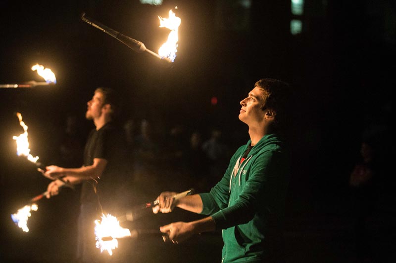 students juggling fire at night