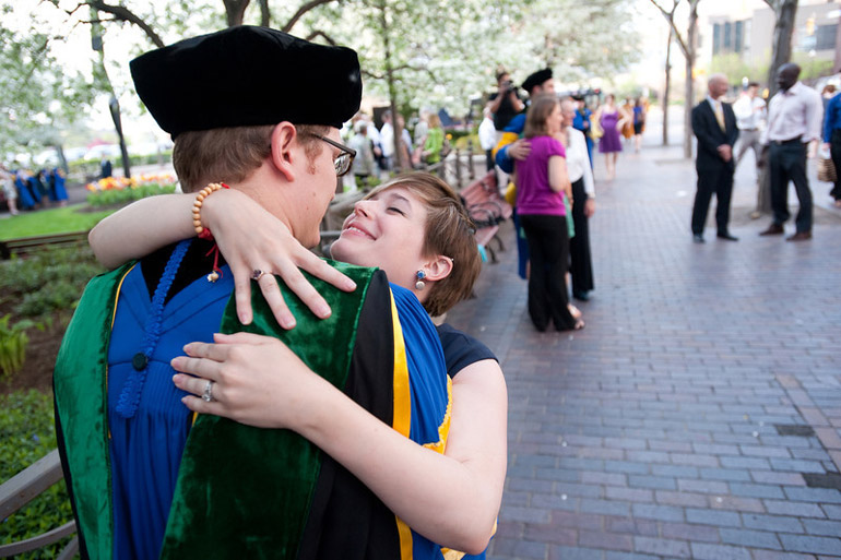 wife hugs graduating student