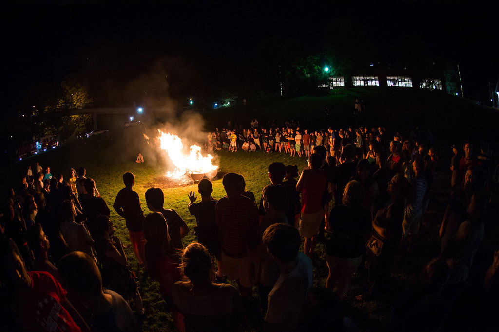 crowd of students gathers around a bonfire