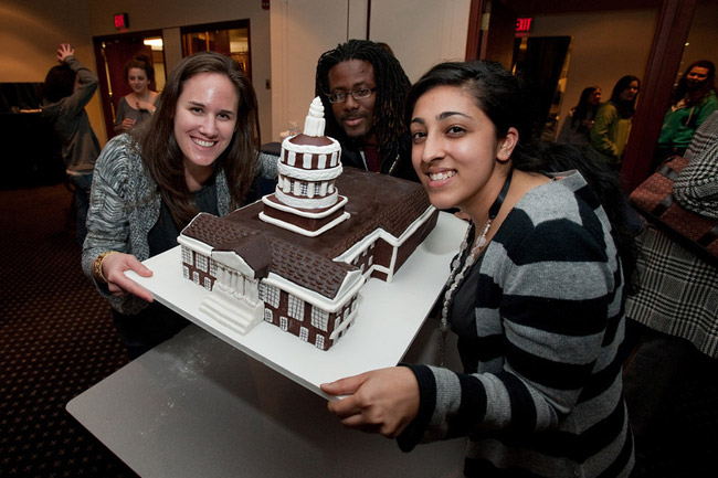 students pose with Rush Rhees Library cake