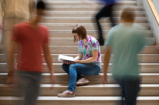 one student sits still while others swirl around her