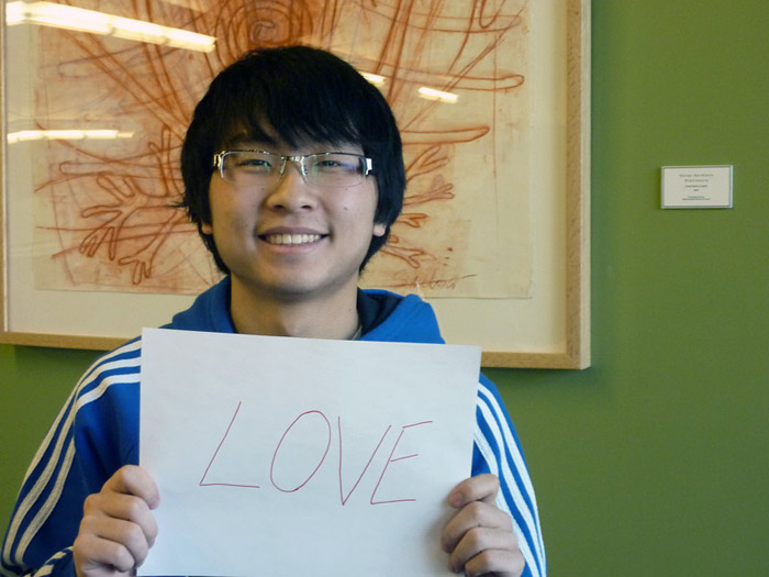 student holding sign that reads LOVE