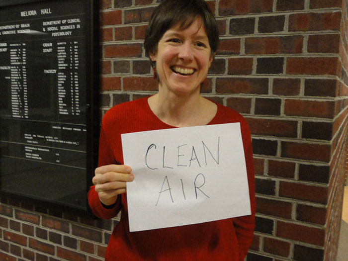 student holding sign that reads CLEAN AIR