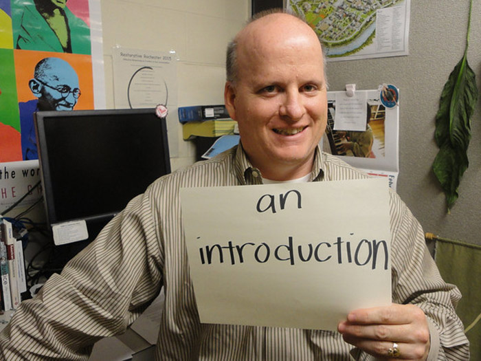 student holding sign that reads AN INTRODUCTION