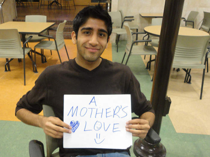 student holding sign that reads A MOTHERS LOVE