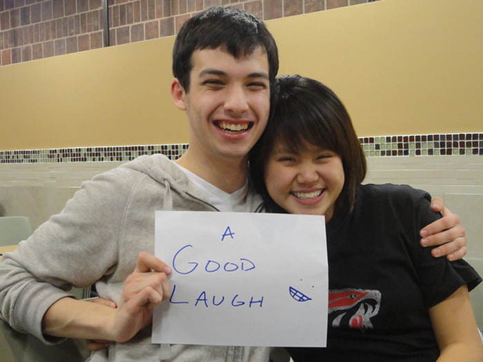 student holding sign that reads A GOOD LAUGH