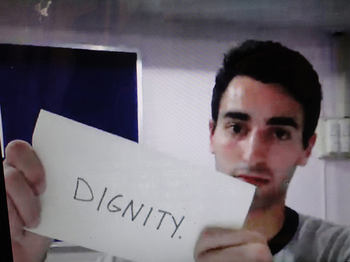 student holding sign that reads DIGNITY