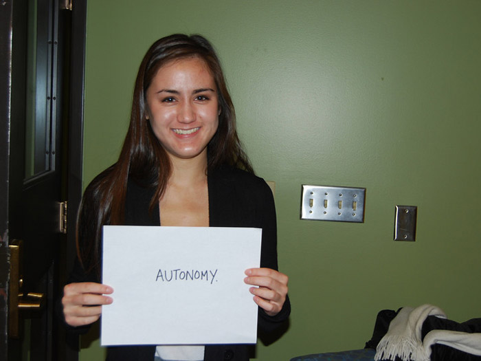 student holding sign that reads AUTONOMY