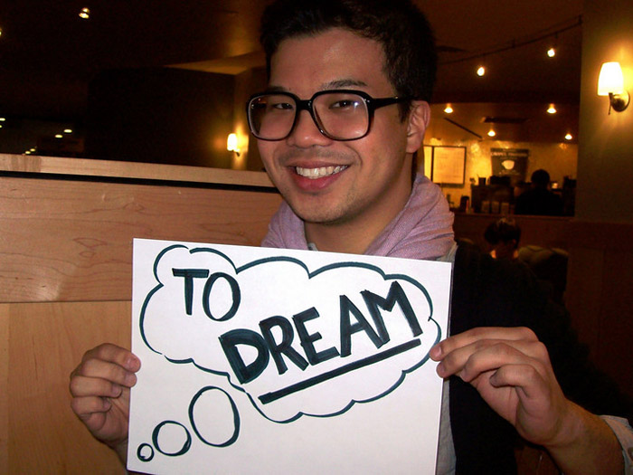 student holding sign that reads TO DREAM