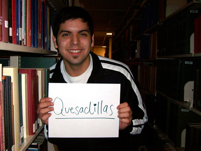 student holding sign that reads QUSADILLAS