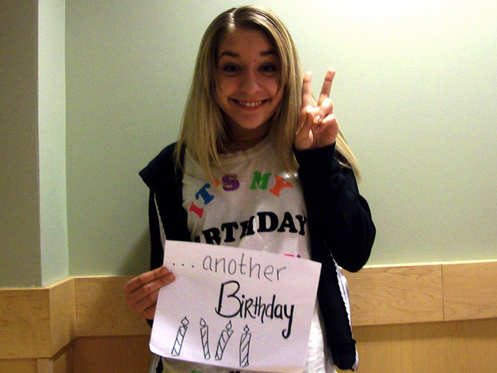 student holding sign that reads ANOTHER BIRTHDAY