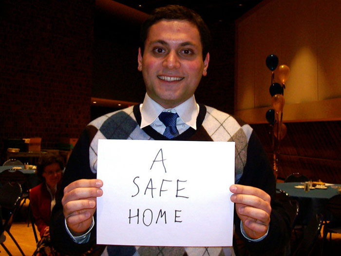 student holding sign that reads A SAFE HOME