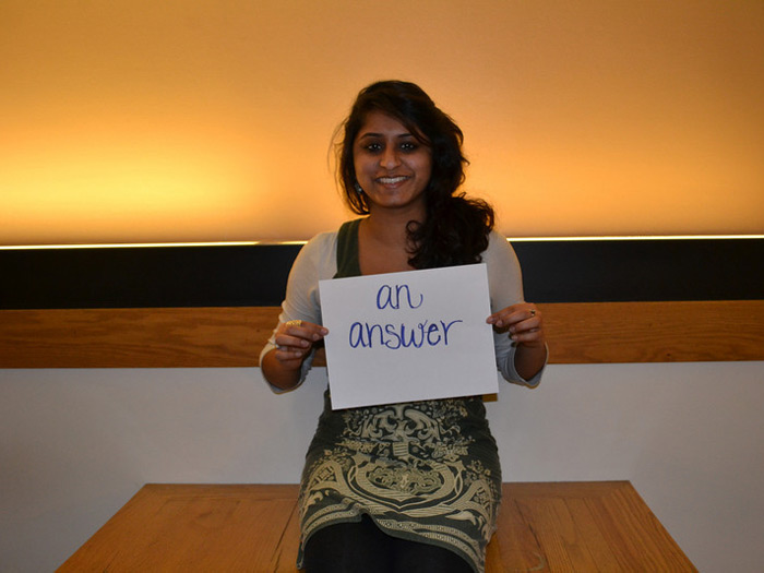 student holding sign that reads AN ANSWER